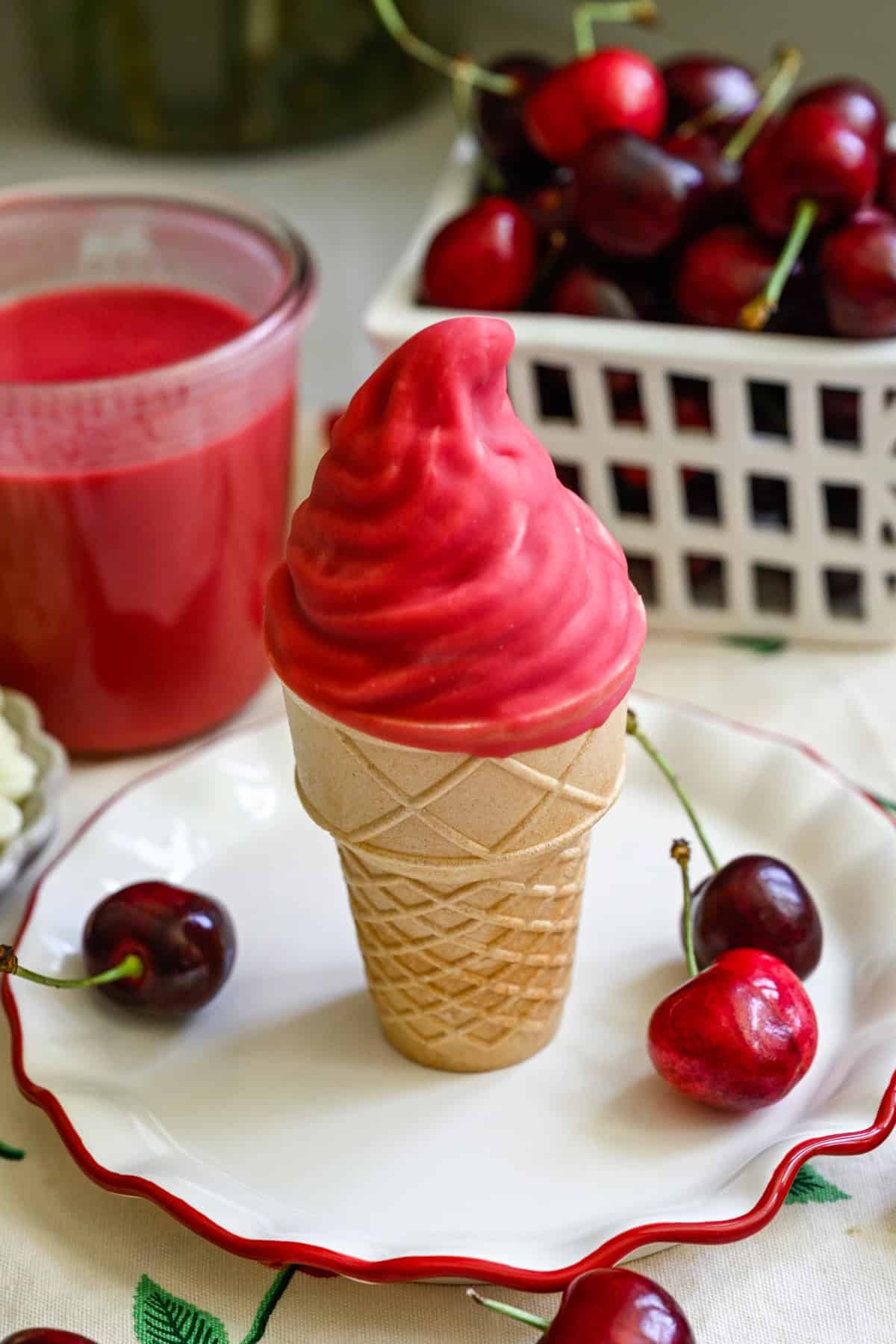 Ice cream cone with vanilla swirl dipped in homemade cherry magic shell.