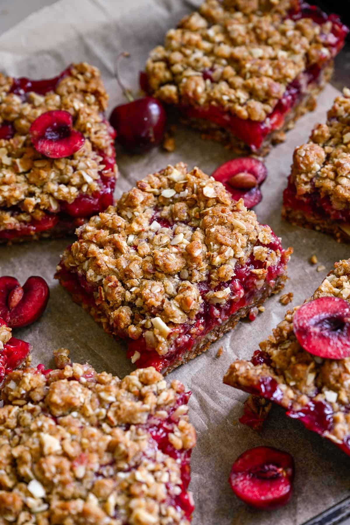 close up view of cherry pie bars on parchment paper. 