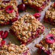close up view of cherry pie bars on parchment paper.