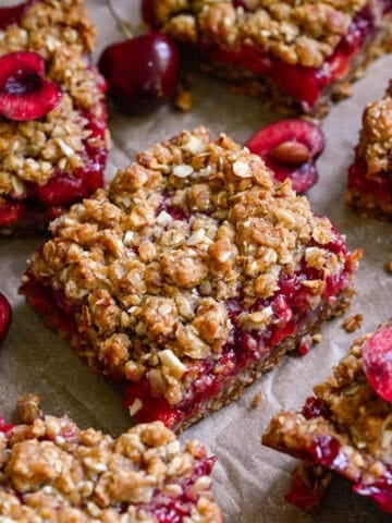 close up view of cherry pie bars on parchment paper.