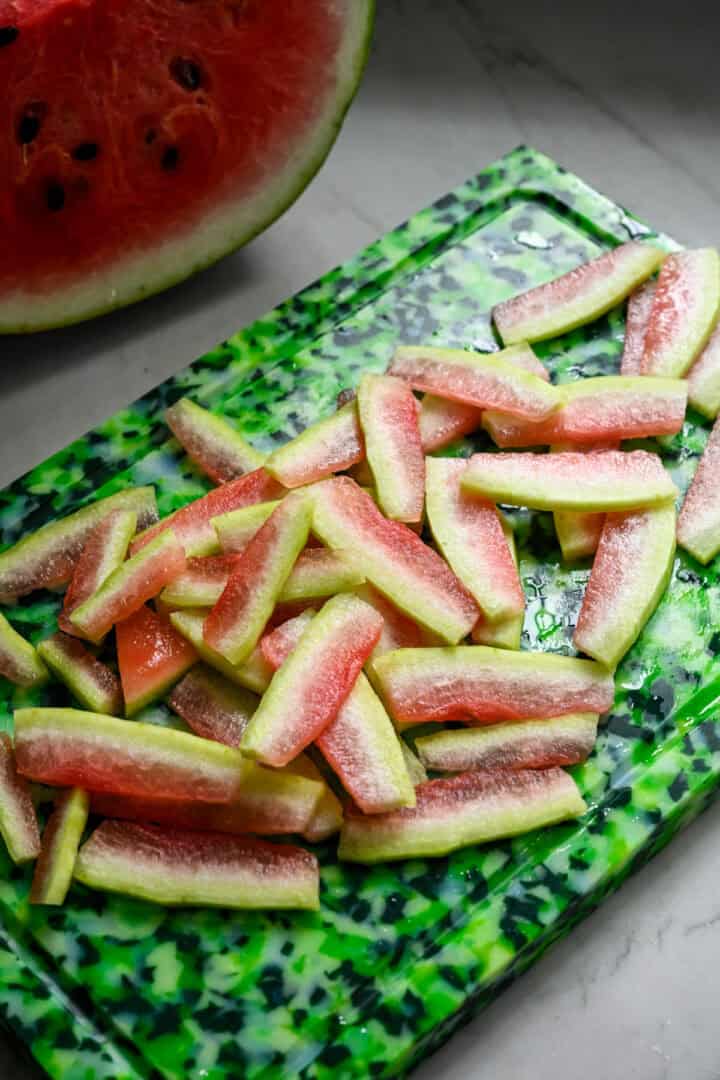Overhead view of watermelon rinds cut into ¼ inch thick pieces.