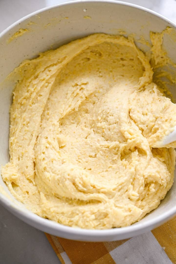 Cornmeal cake batter in white mixing bowl.