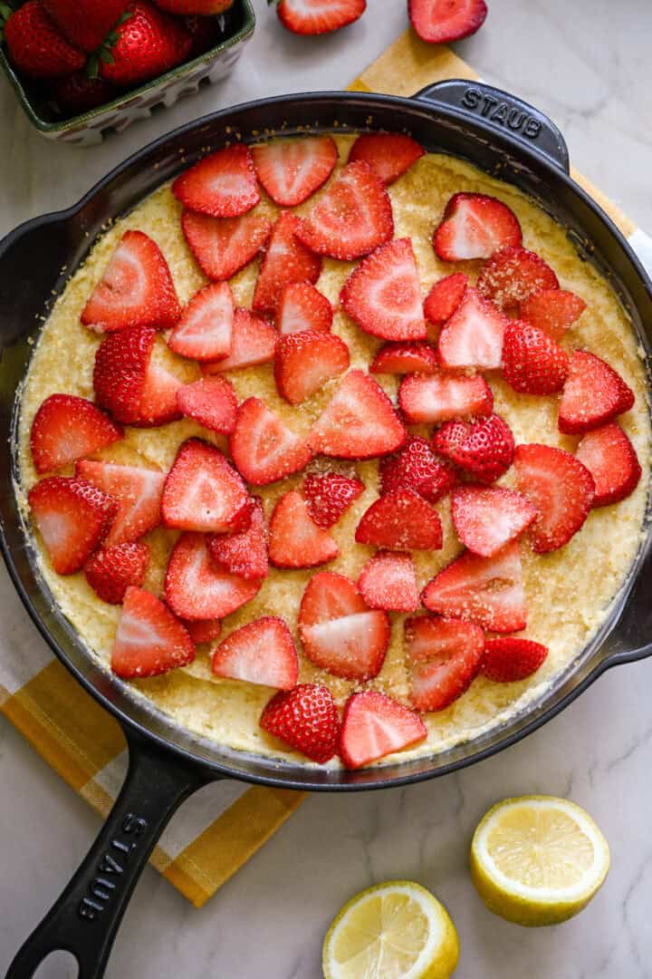 Strawberry cornmeal cake in a cast iron skillet before baking.