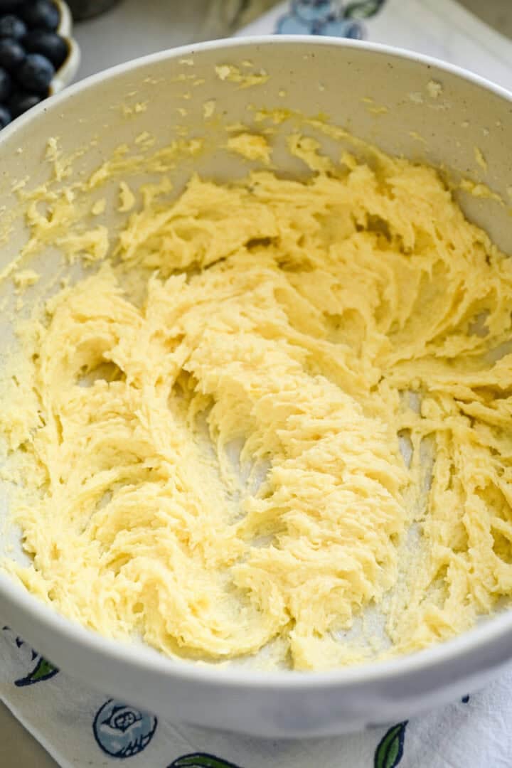 Butter and sugar and eggs mixed together in a bowl.