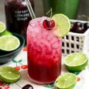 Front view of cherry lime soda in a glass.