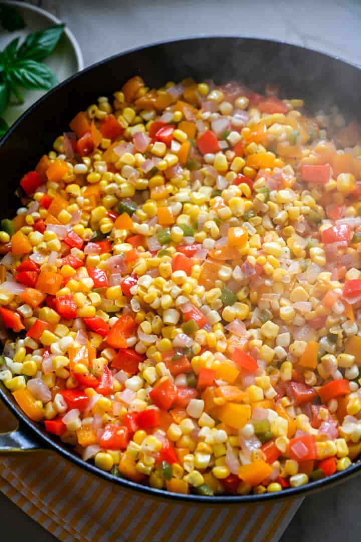 confetti corn in a skillet before adding back the bacon and herbs.