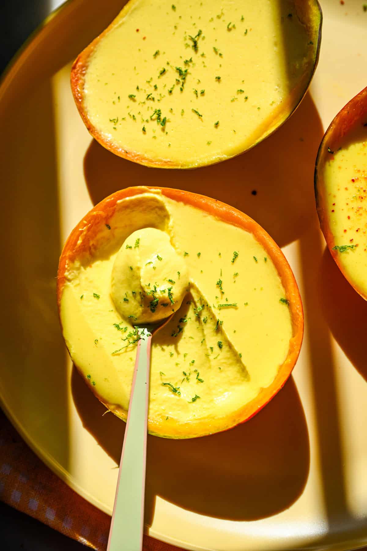 Overhead view of mango posset with a scoop taken out.