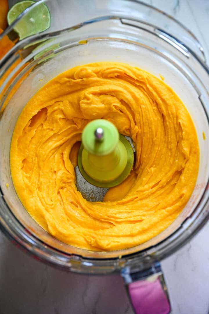 Mango sorbet ingredients in a food processor after blending.