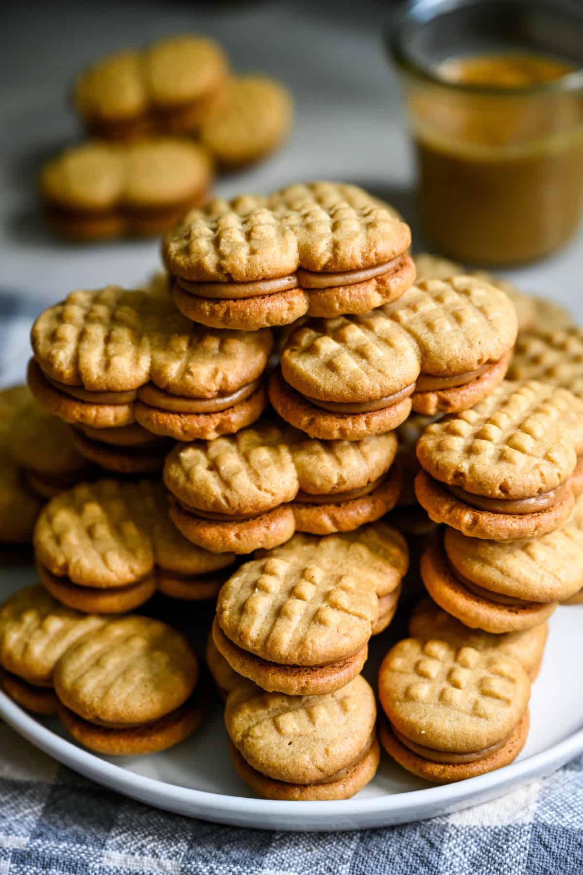 A big stack homemade nutter butters on a white plate.