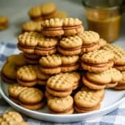 A big stack homemade nutter butters on a white plate.