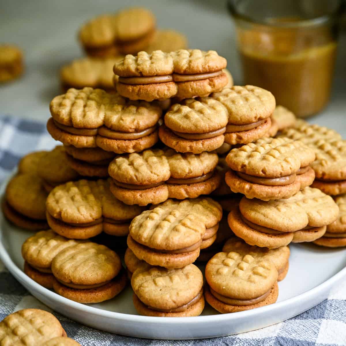 A big stack homemade nutter butters on a white plate.