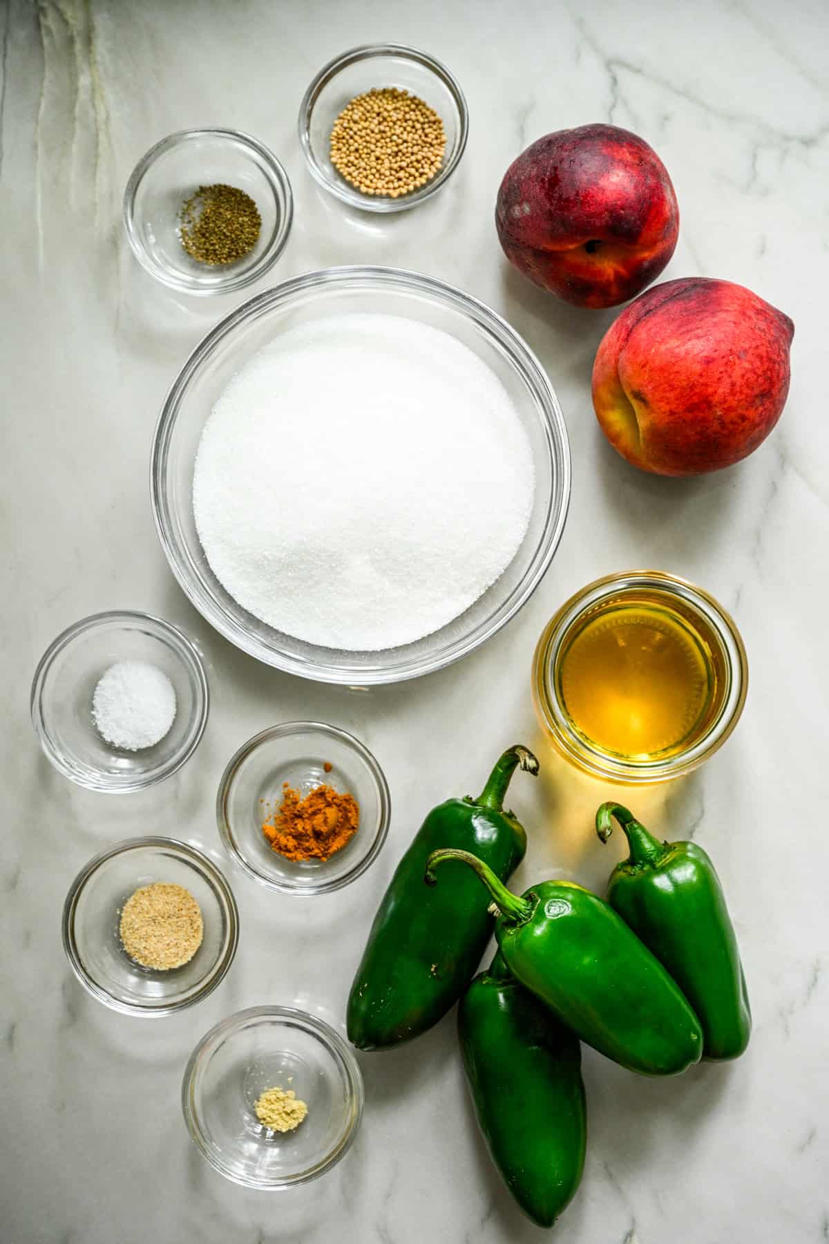 Overhead view of peach cowboy candy ingredients, including sugar and jalapenos.