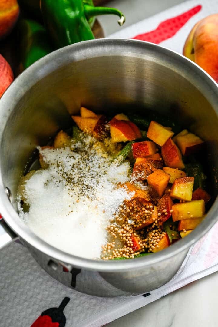 Overhead view of cowboy candy ingredients in a small stainless steel saucepan.