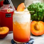 Front view of peach dirty soda in a glass.