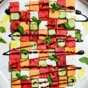 overhead view of watermelon checkerboard salad with squares of melon, cucumber, tomato and feta.