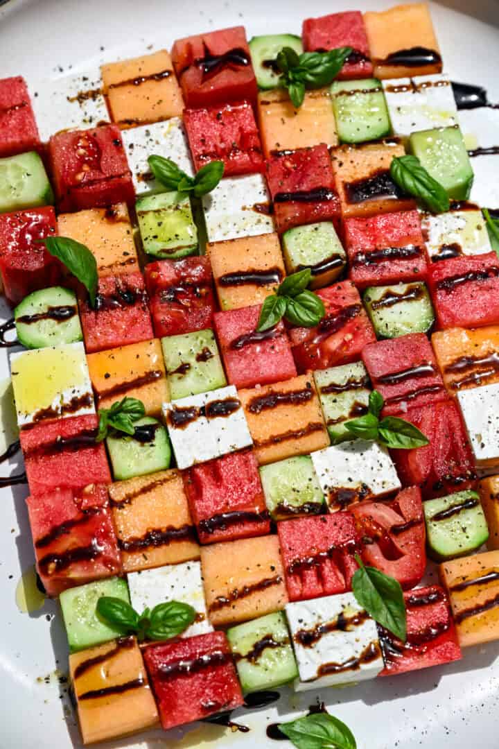 overhead view of watermelon checkerboard salad with squares of melon, cucumber, tomato and feta.