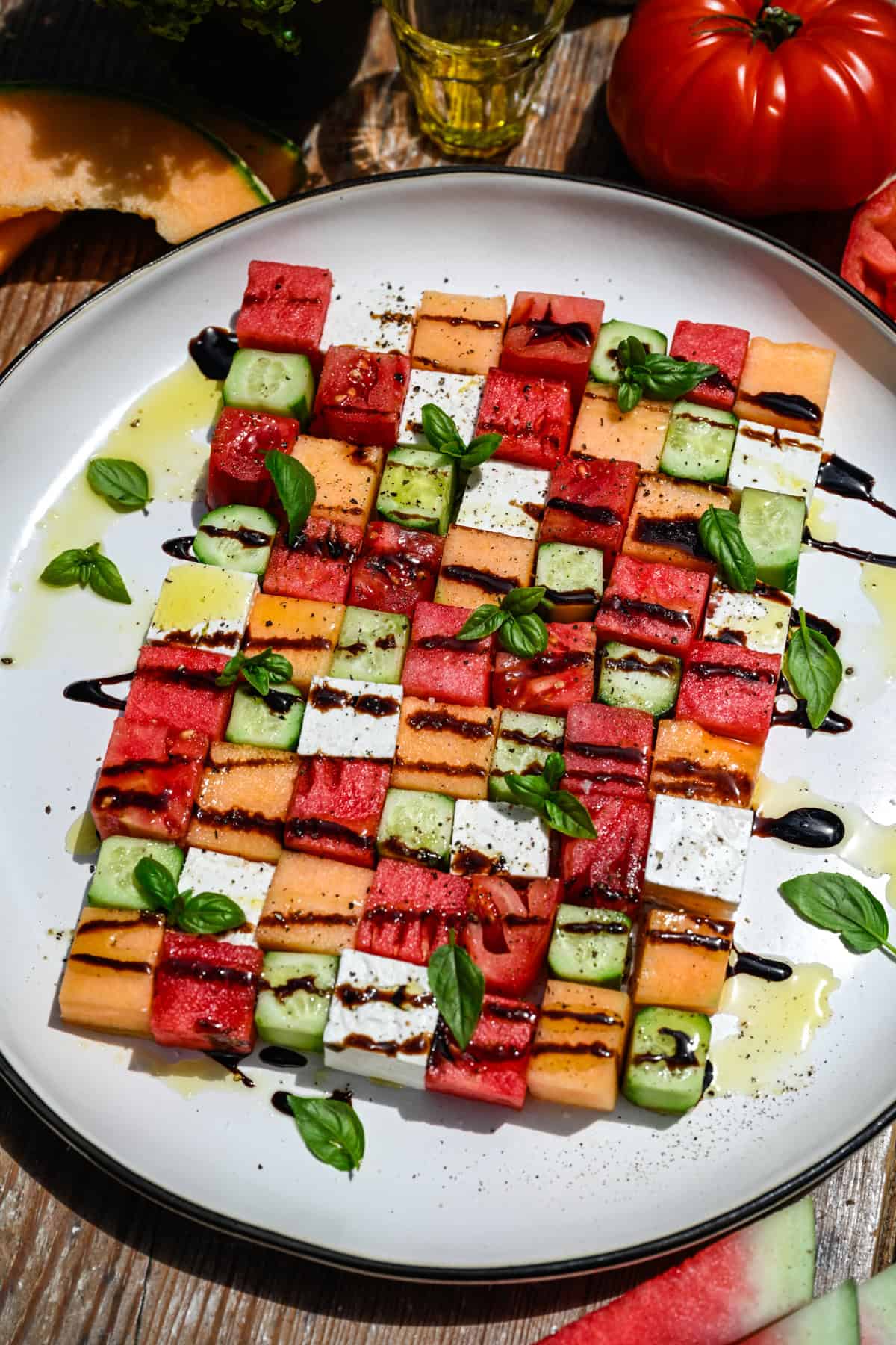 overhead view of watermelon checkerboard salad with squares of melon, cucumber, tomato and feta.