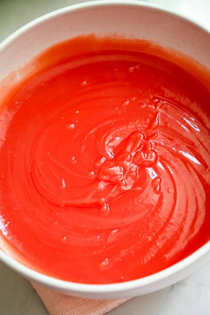 Overhead view of watermelon pudding in a white bowl.