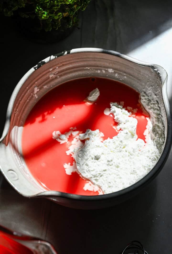 Overhead view of cornstarch and watermelon juice slurry.