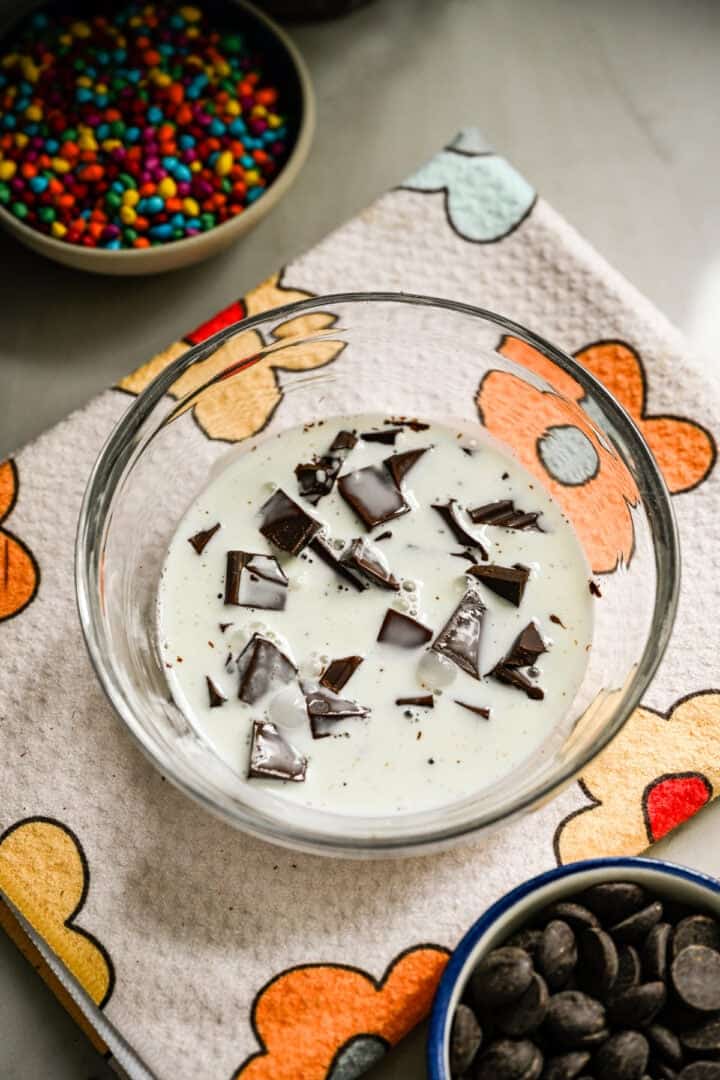 Chocolate and heavy cream in a bowl before being whisked into a ganache.