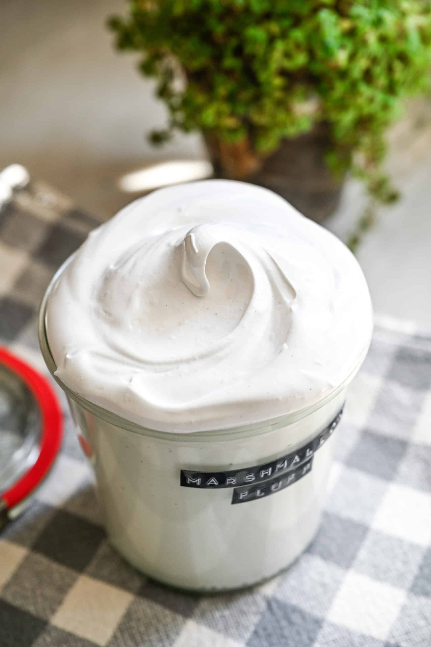 Close up view of homemade marshmallow fluff in a glass jar.