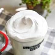 Close up view of homemade marshmallow fluff in a glass jar.