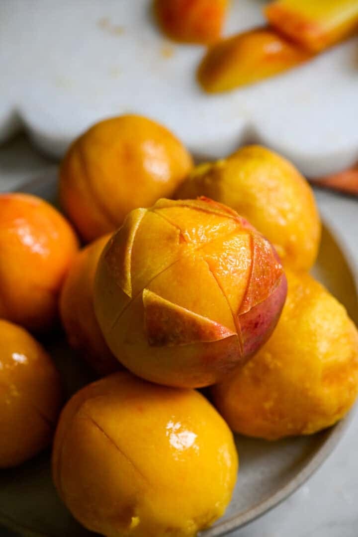 Peach with corners of skin pulled back on them.
