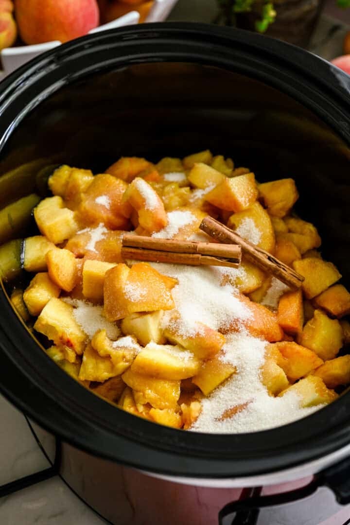 Overhead view of peach butter in a slow cooker.