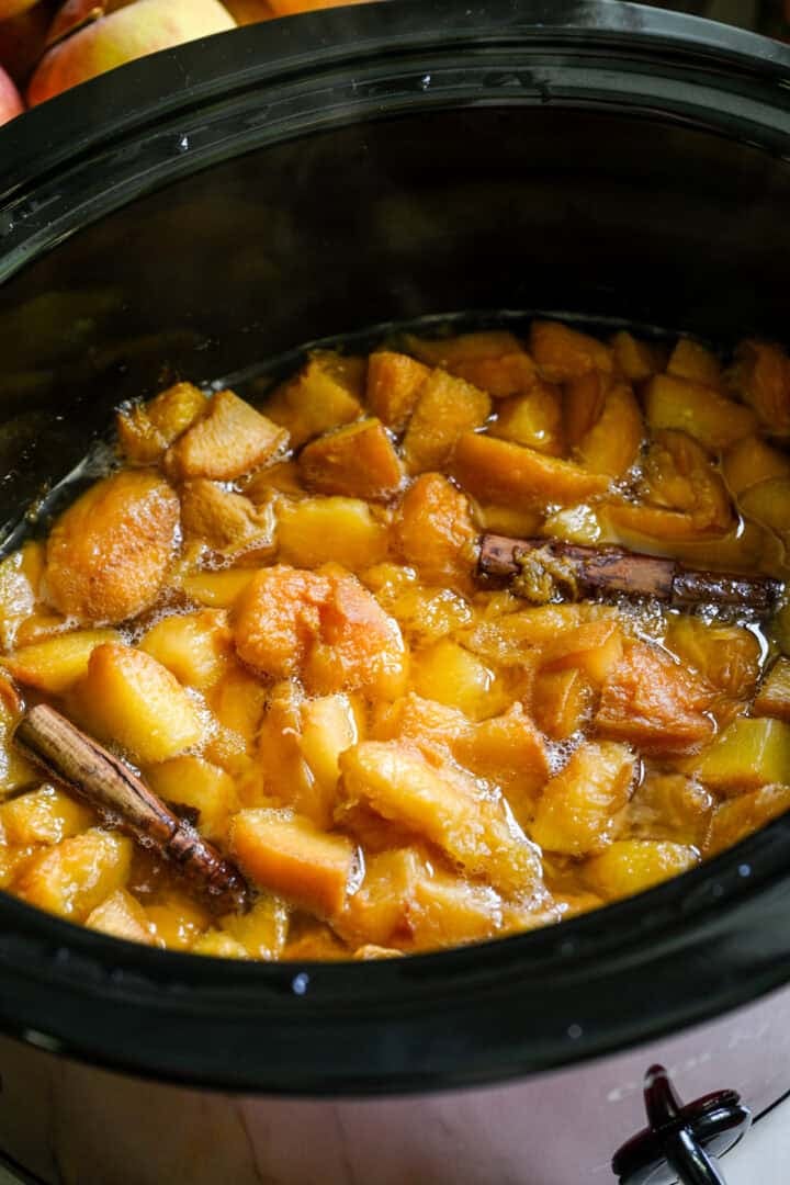 Overhead view of peach butter in a slow cooker.