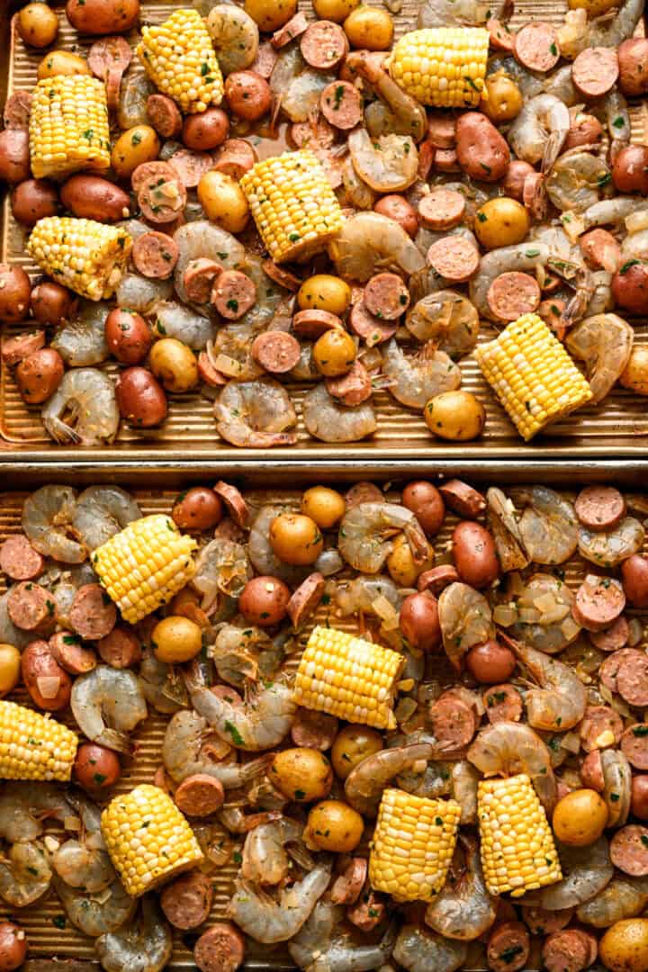 2 sheet pans of sheet pan shrimp boil ingredients before baking.