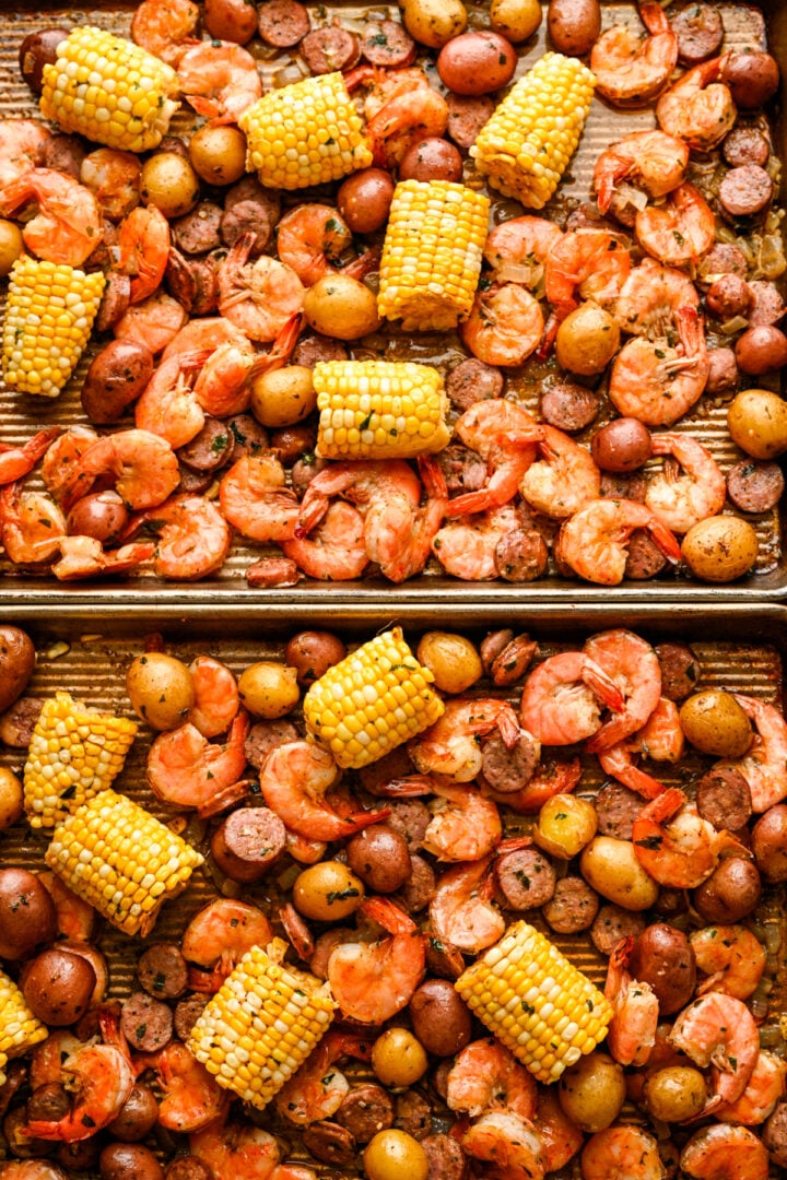 2 sheet pans of sheet pan shrimp boil ingredients after baking.
