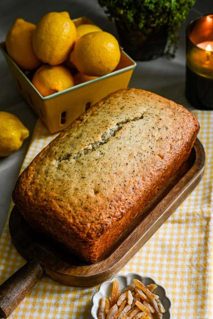 Whole earl grey yuzu loaf cake on a cutting board before being iced.