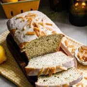 Yuzu earl grey loaf cake with a few slices sliced on cutting board.