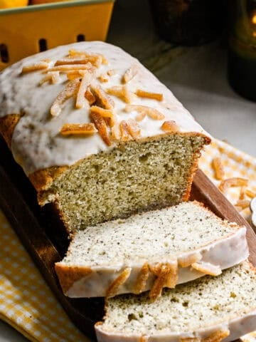Yuzu earl grey loaf cake with a few slices sliced on cutting board.
