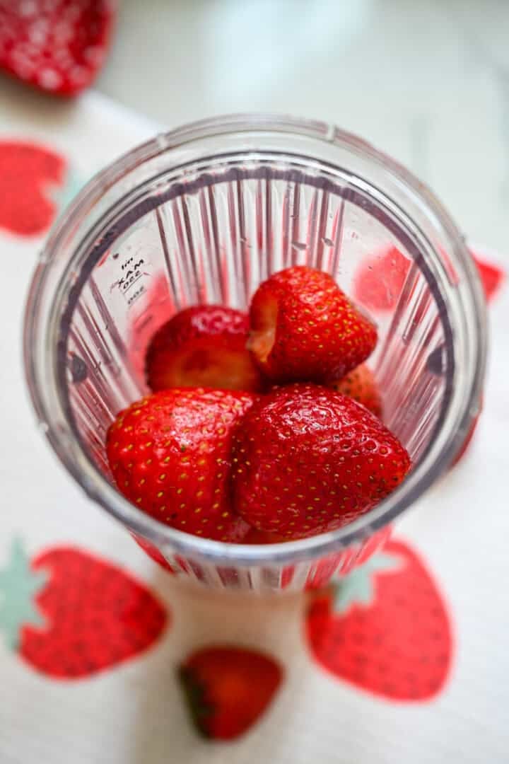 Strawberries in a bullet blender before blending.