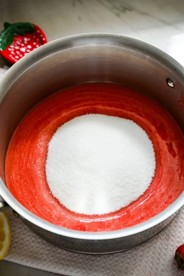 Overhead view of strawberry puree and sugar.