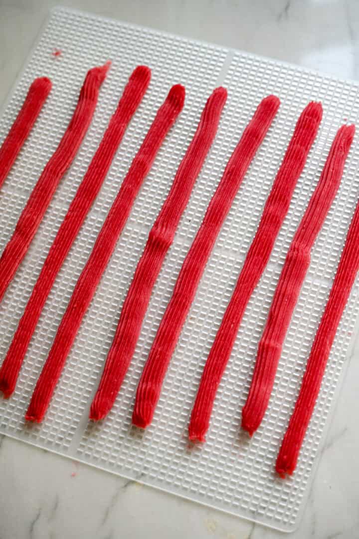 Overhead view of twizzlers on a dehydrator tray.