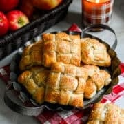 Overhead view of several apple hand pies on a rustic serving tray.