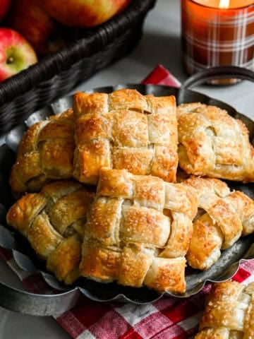 Overhead view of several apple hand pies on a rustic serving tray.