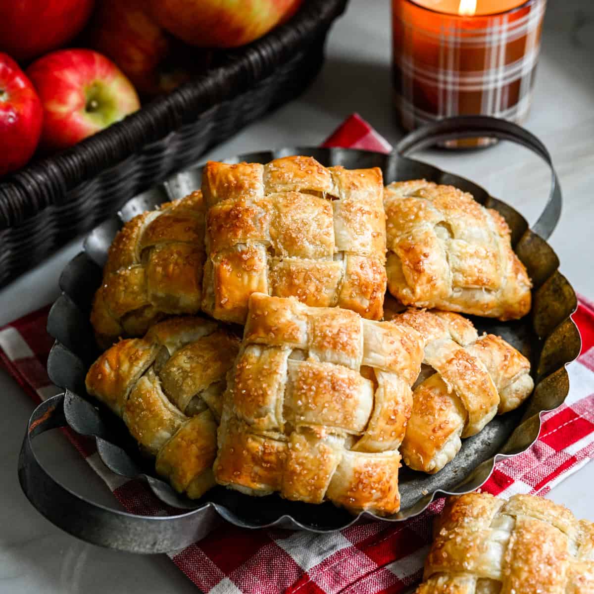 Overhead view of several apple hand pies on a rustic serving tray.