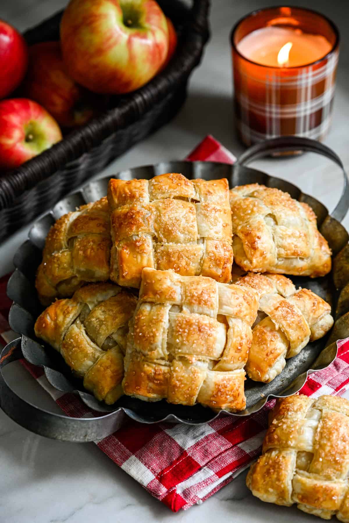 Overhead view of several apple hand pies on a rustic serving tray.