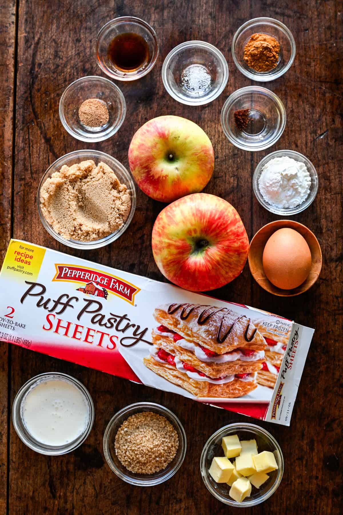 Overhead view of mini apple pie ingredients, including apples and puff pastry.