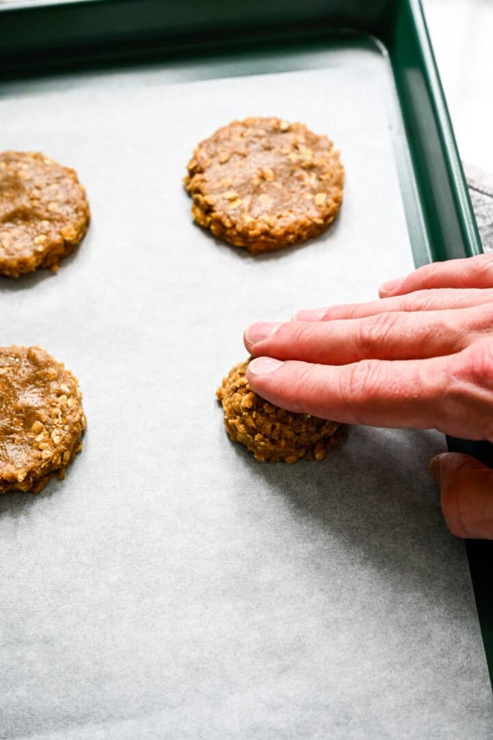 Patting down oatmeal cream pies before baking.
