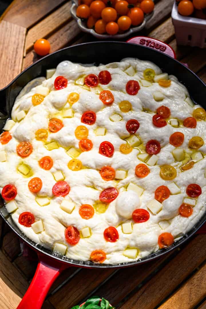 tomato focaccia in skillet before baking.