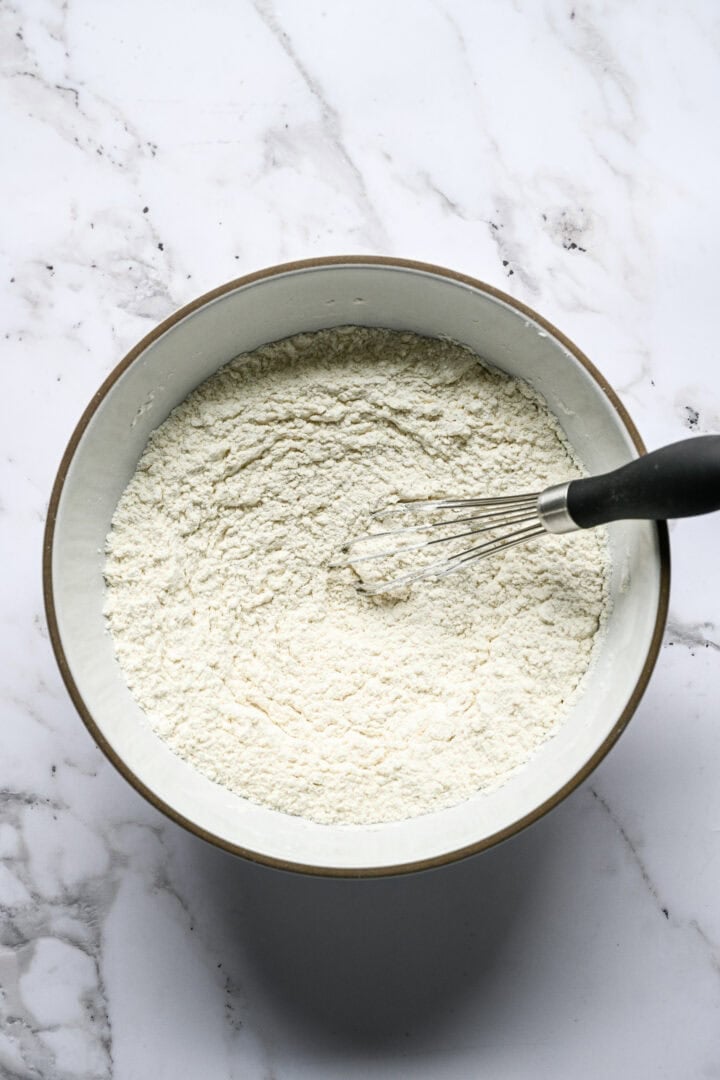 Flour, cornstarch and salt being whisked together in a large bowl.