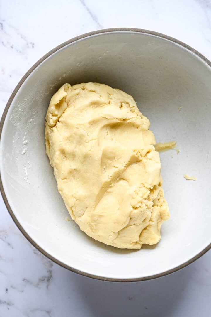 A ball of plain shortbread dough in a mixing bowl.
