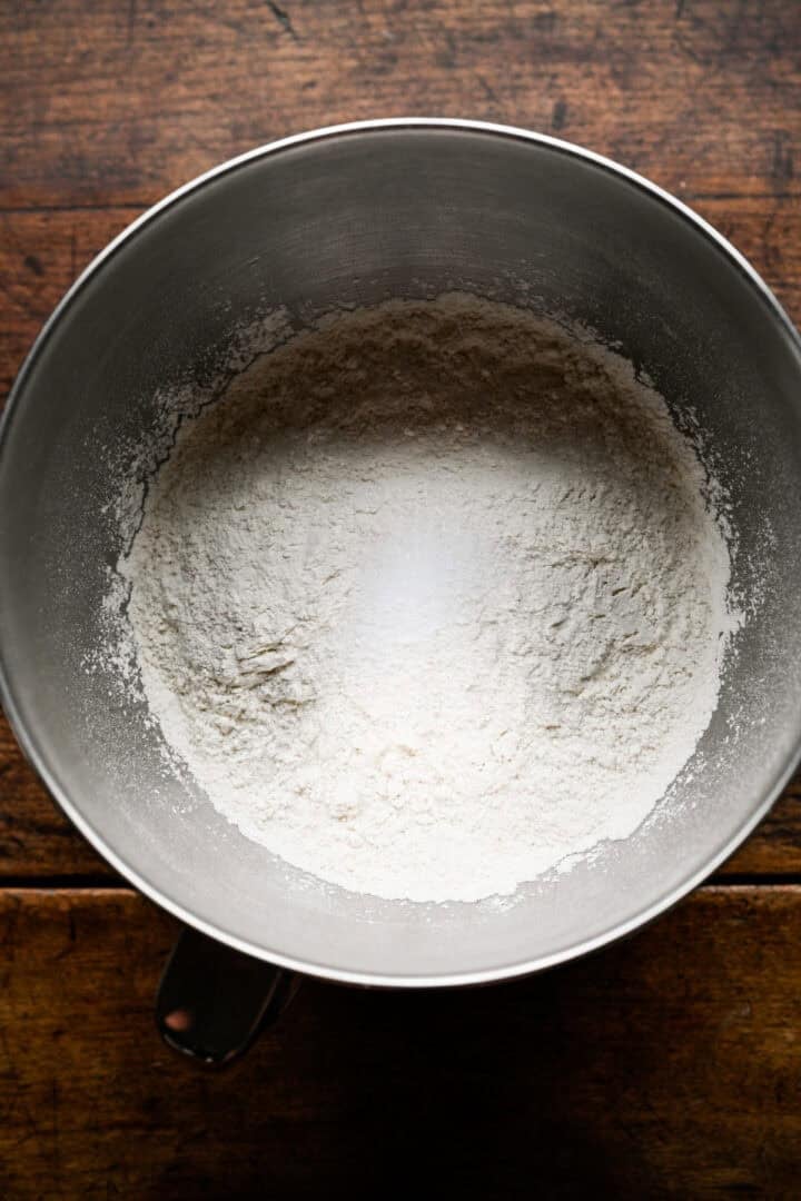Flour and salt in a stainless steel stand mixer bowl, before the wet ingredients are added.