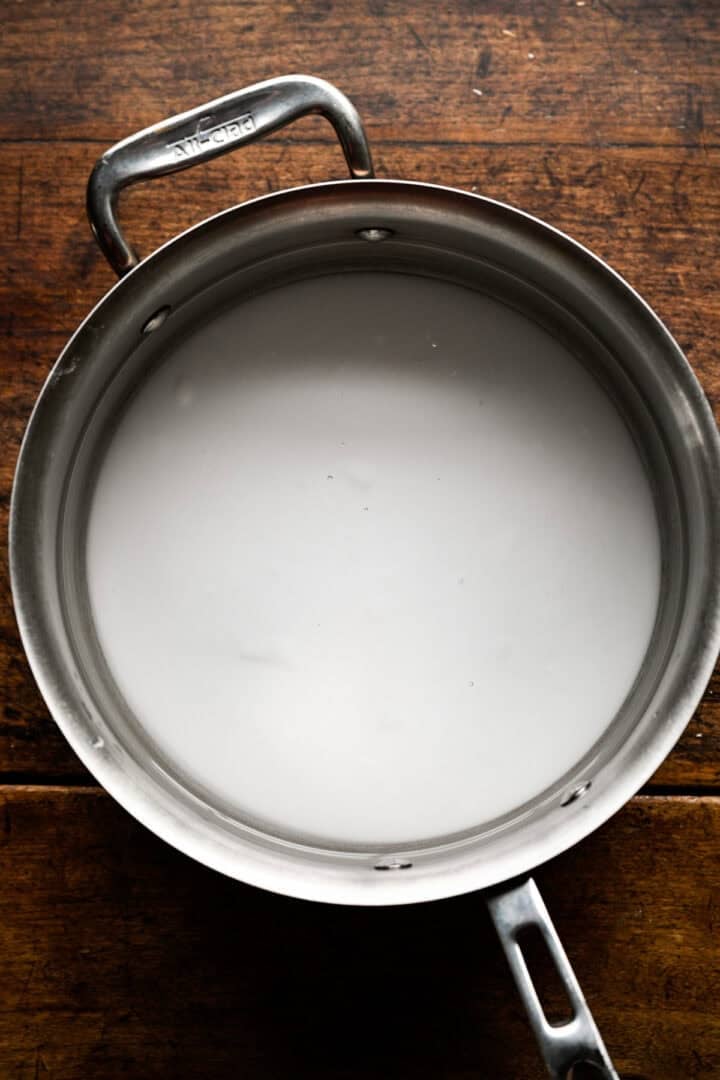 Cloudy baking soda and water solution in a stainless steel saucepan.