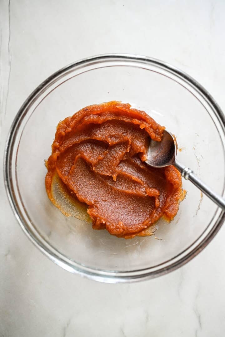 Super smooth date puree in a glass bowl.