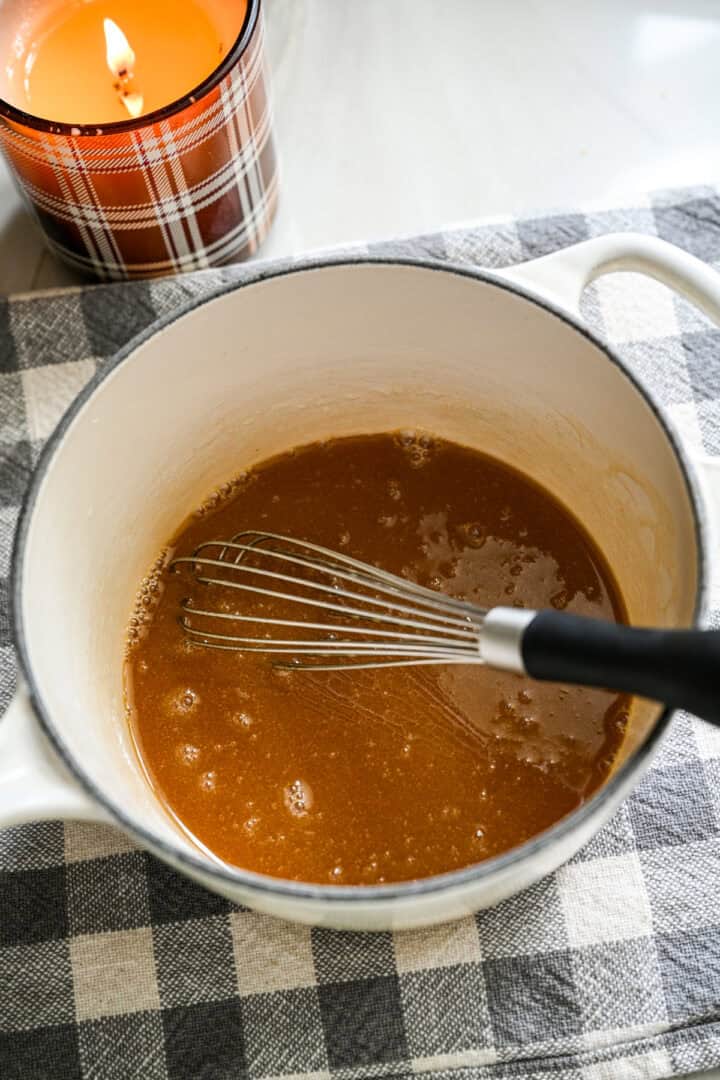 Butter and maple syrup whisked together in small white saucepan.
